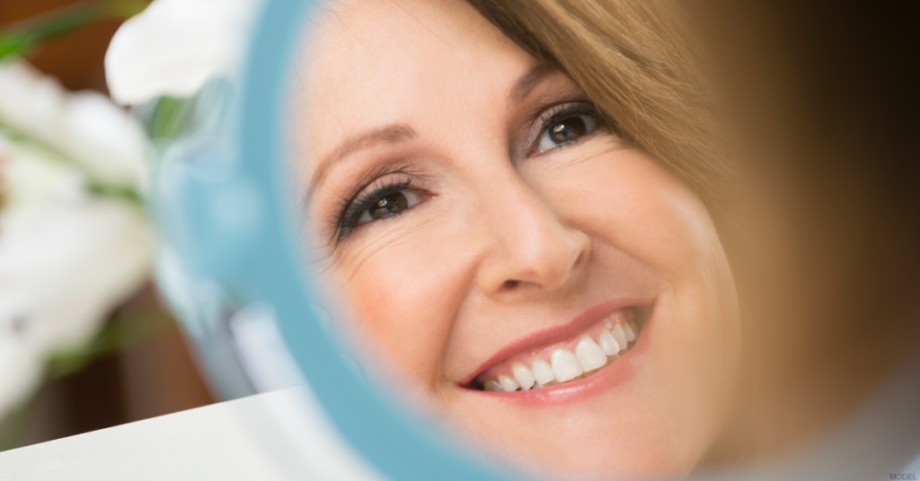 Close-up of a woman looking at her reflection in a mirror.