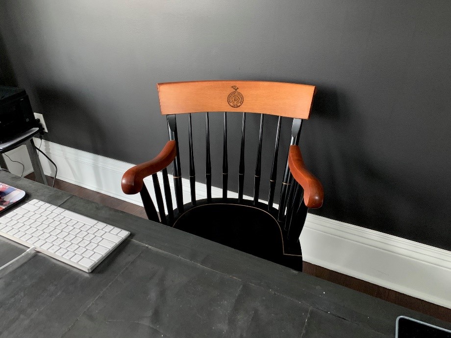 A photo of the engraved wooden banker's chair gifted to him from his medical school upon graduation.