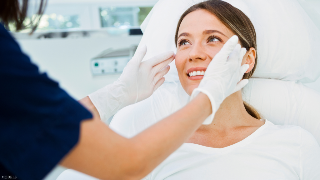 Doctor analyzing woman's face with gloves (models)