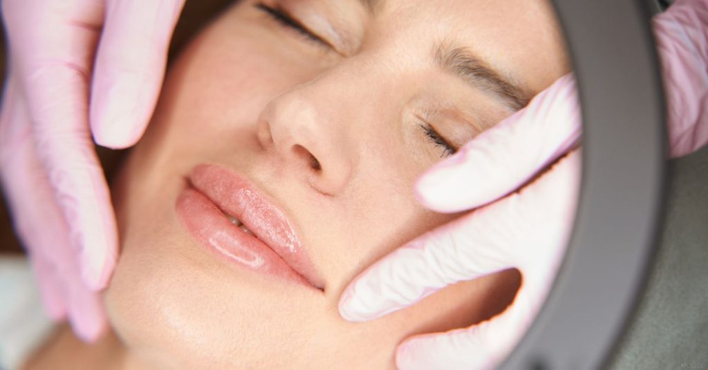 Woman viewing her filler results in a mirror (model)