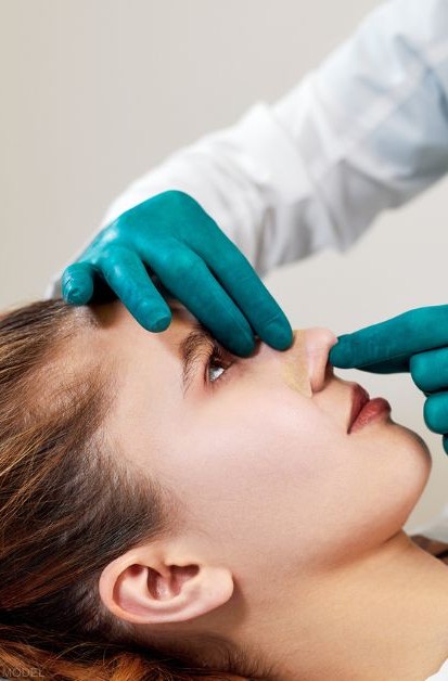 Woman having nose examined by a doctor during a medical consultation (MODEL)