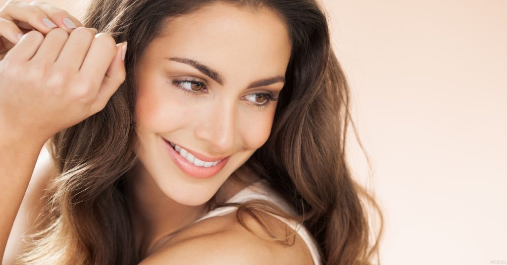 Woman showcasing facial rejuvenation results after dermal filler treatment. (Model)